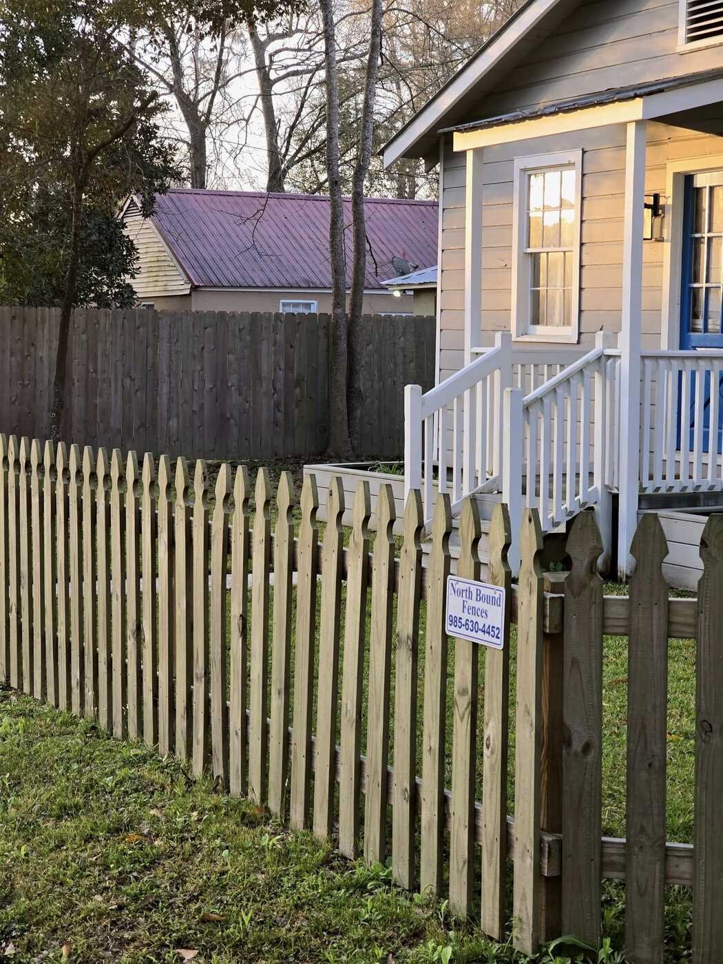 Wood picket fence with a Northbound Fences sign on the gate